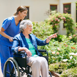 Shot of a resident and a nurse outside in the retirement home garden