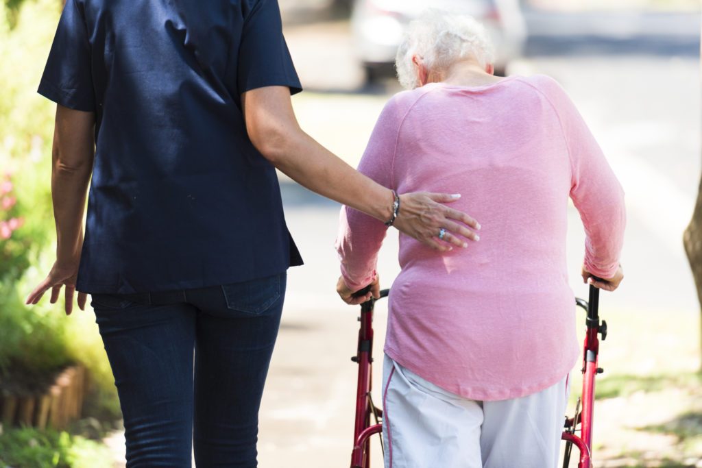 iStock-519048734-1024x683 The back of a nurse and a senior lady taking a walk
